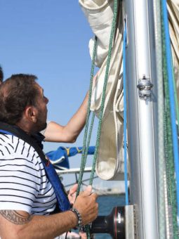 un client qui hisse la grand voile à bord de kelone